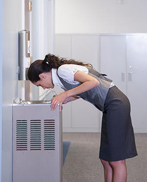 Woman drinking water from a water fountain